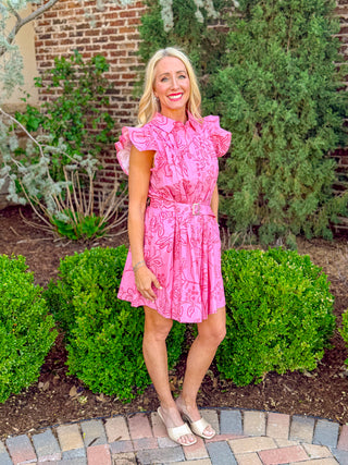 Pink floral mini dress with ruffle sleeves, belted waist, and flowy skirt shown at an angle