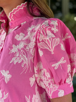 Close-up of pink puff sleeve blouse showcasing intricate ivory floral embroidery, dragonfly accents, gathered sleeve detail, and scalloped collar trim.