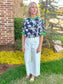 Navy floral embroidered top with green ruffle trim paired with ivory high waisted wide leg culottes and neutral sandals, chic boutique spring outfit