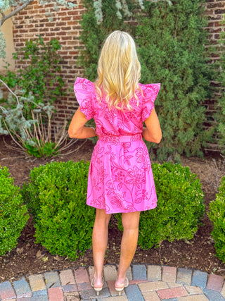 Back view of pink floral eyelet mini dress with ruffle sleeves and cinched waist detail