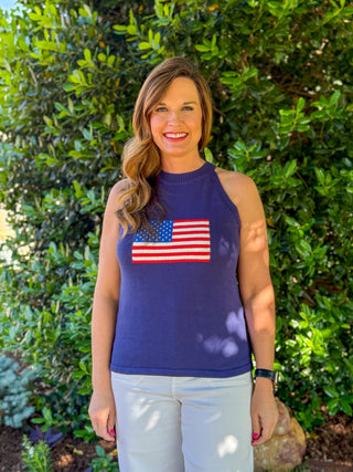 Navy halter knit sweater top with American flag design on front styled with white pants, boutique patriotic outfit for summer and Fourth of July