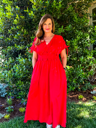 Red midi dress with floral waist detail, short tie sleeves, and flowy skirt shown front view styled for boutique spring and summer occasions