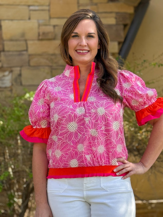 Pink floral embroidered blouse with puff sleeves and contrast trim neckline styled with white pants for women’s boutique fashion