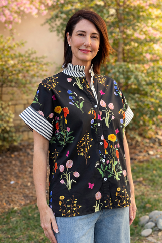 black floral cotton blouse with ruffle collar and short sleeves on model