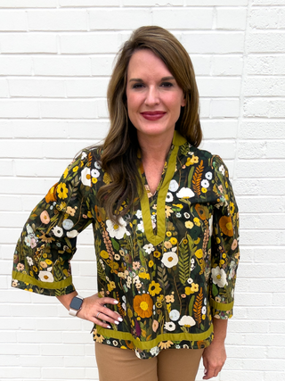 Women’s olive green floral blouse with three-quarter sleeves and contrast trim styled with camel wide-leg pants