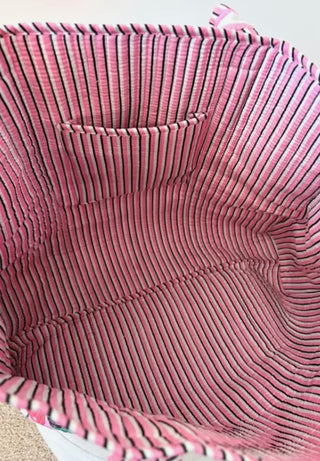 Interior of pink striped quilted tote bag featuring inner pocket and spacious design for everyday use