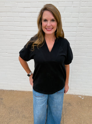 Black short sleeve V-neck blouse for women with subtle puff sleeves and relaxed silhouette
